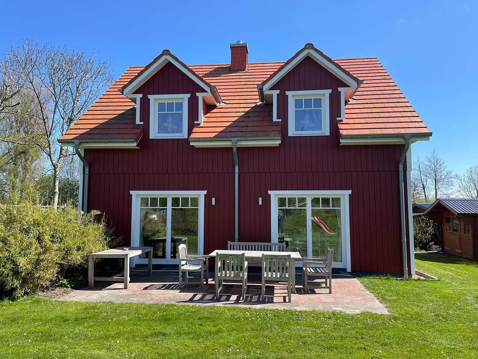 Ferienhaus Deichstern – Terrasse mit Möbeln und Blick ins Grüne, Urlaub zu zweit oder Familie