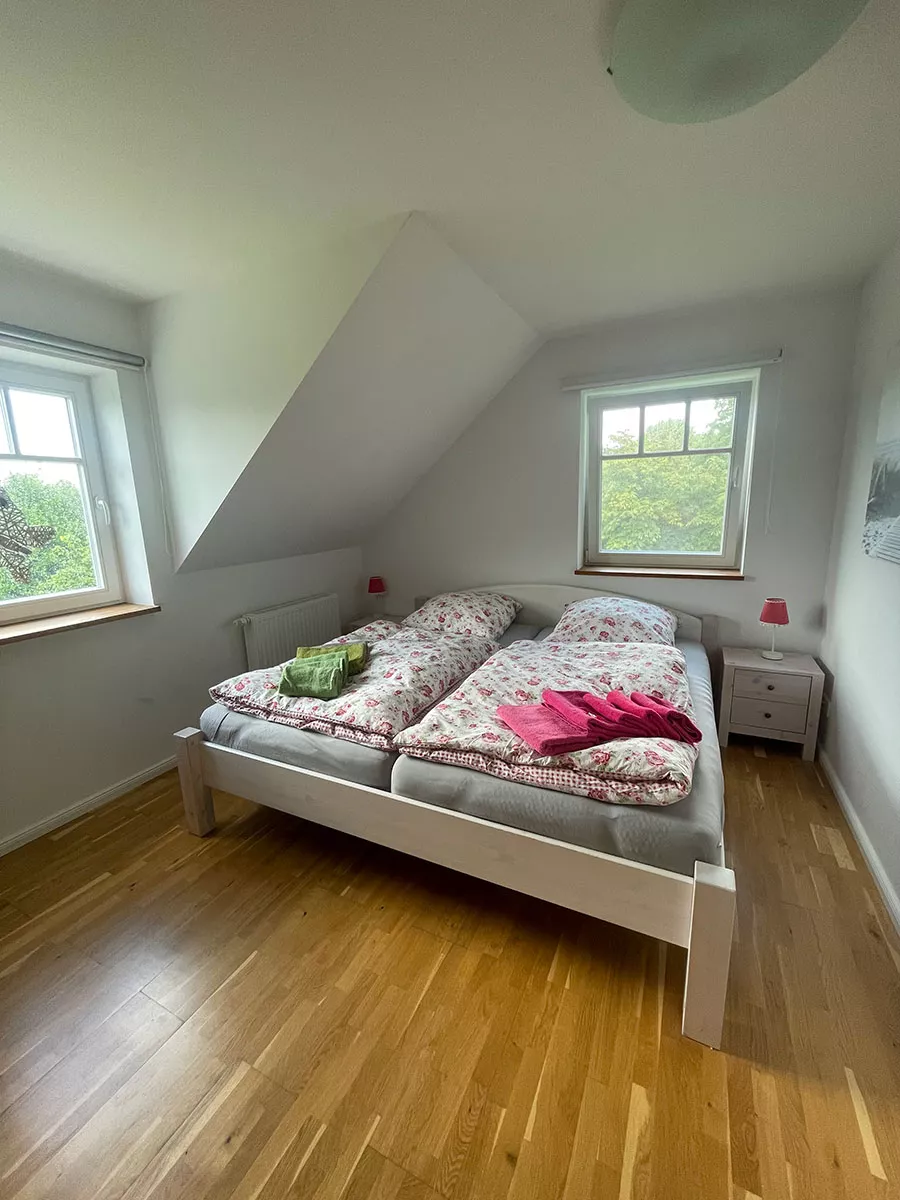 Ferienhaus Deichstern – Schlafzimmer mit Doppelbett und Blick ins Grüne, Urlaub in der Natur