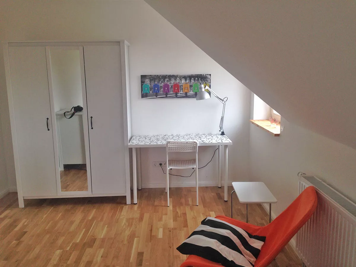 Ferienhaus Deichstern – Kinder- oder Gästezimmer mit Schrank, Sitzgelegenheit und Tisch