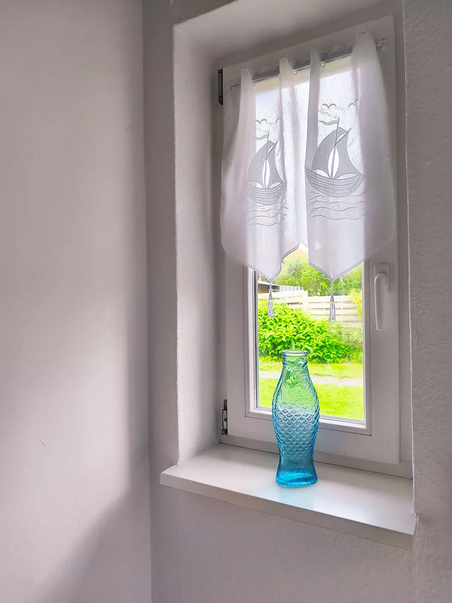 Ausblick ins Grüne vom Treppenaufgang im Ferienhaus Deichsonne, Dekoration mit Fisch-Karaffe